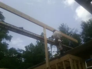 Carpenter setting a ridge beam over a new addition frame — Ice Dam Removal by Roofing Brothers in The Villages