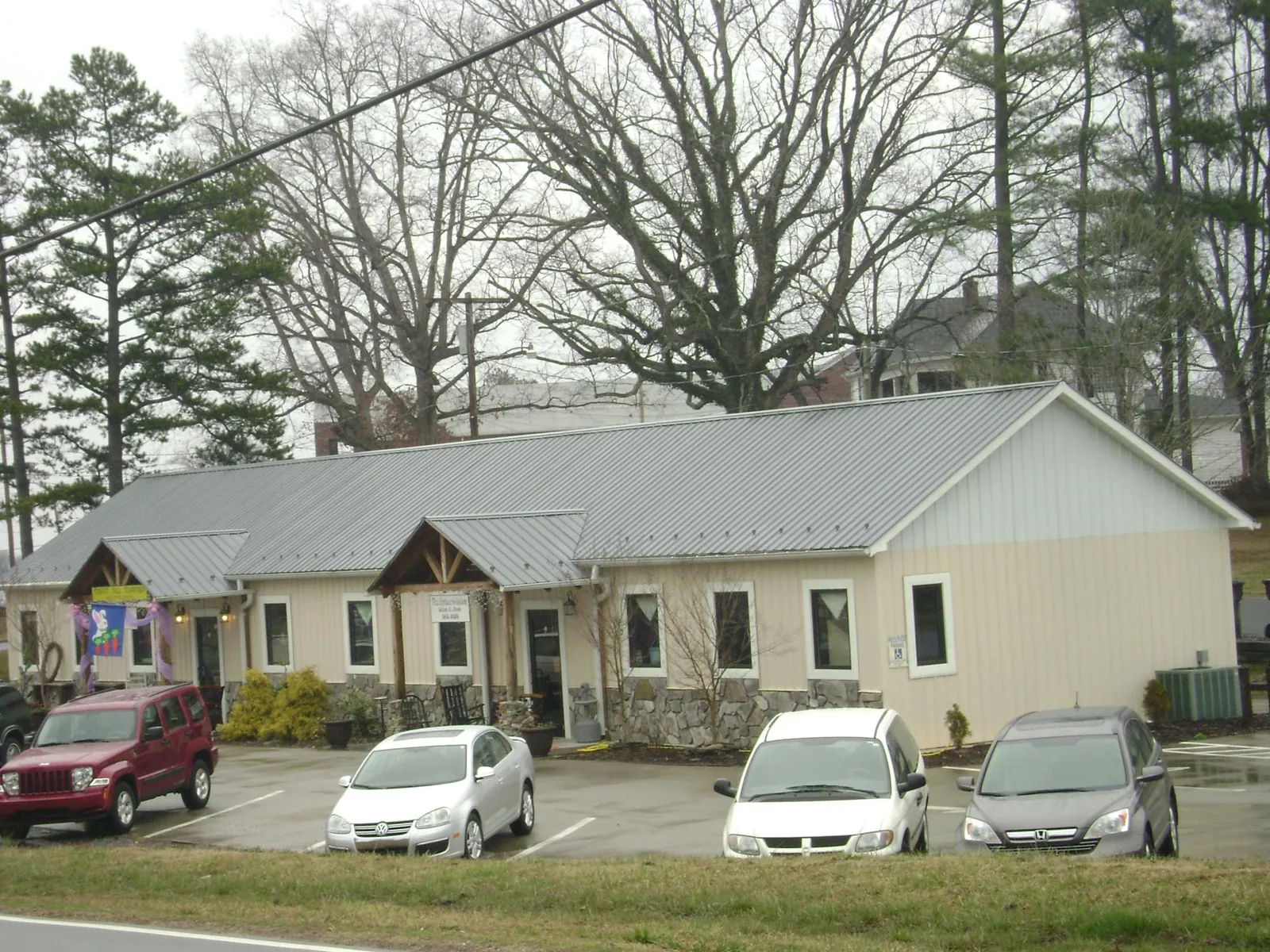 Gray metal roof with timber entry brackets on a small commercial building in The Villages