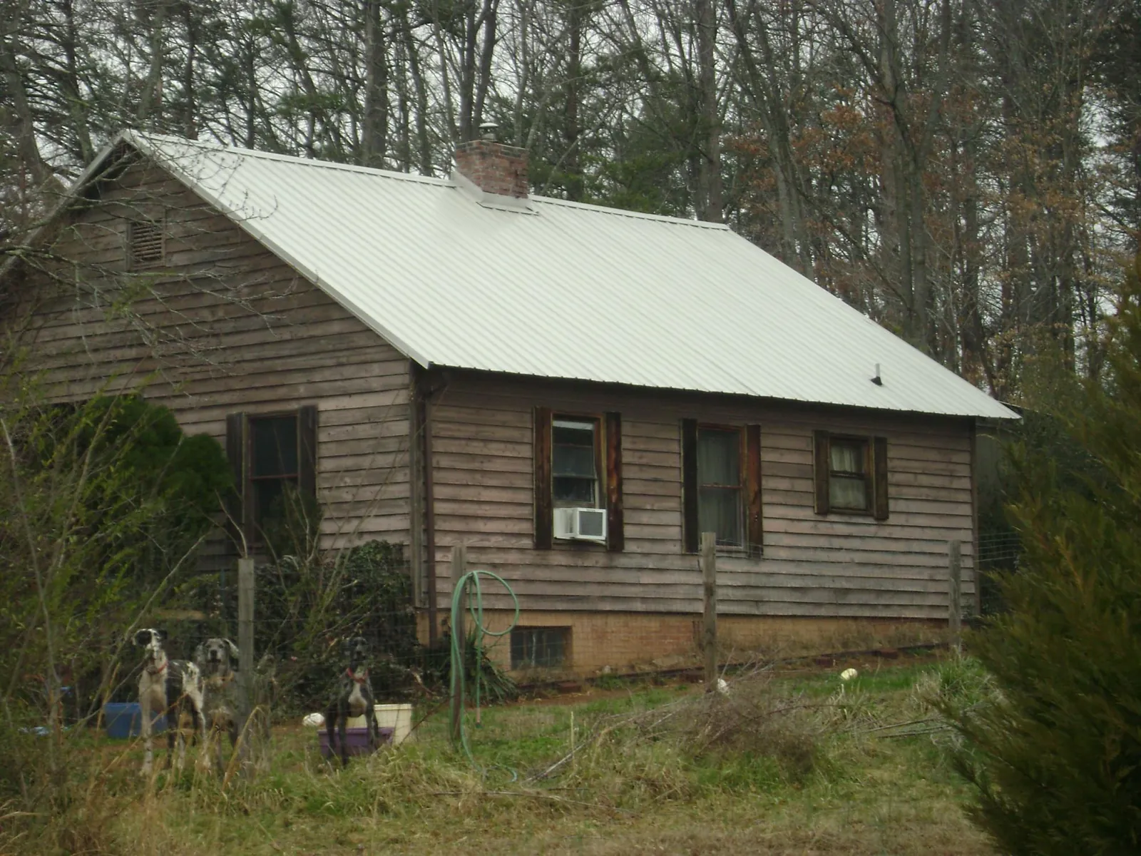 White metal roof on an old wood sided farmhouse, from a Metal Roof Installation job in The Villages
